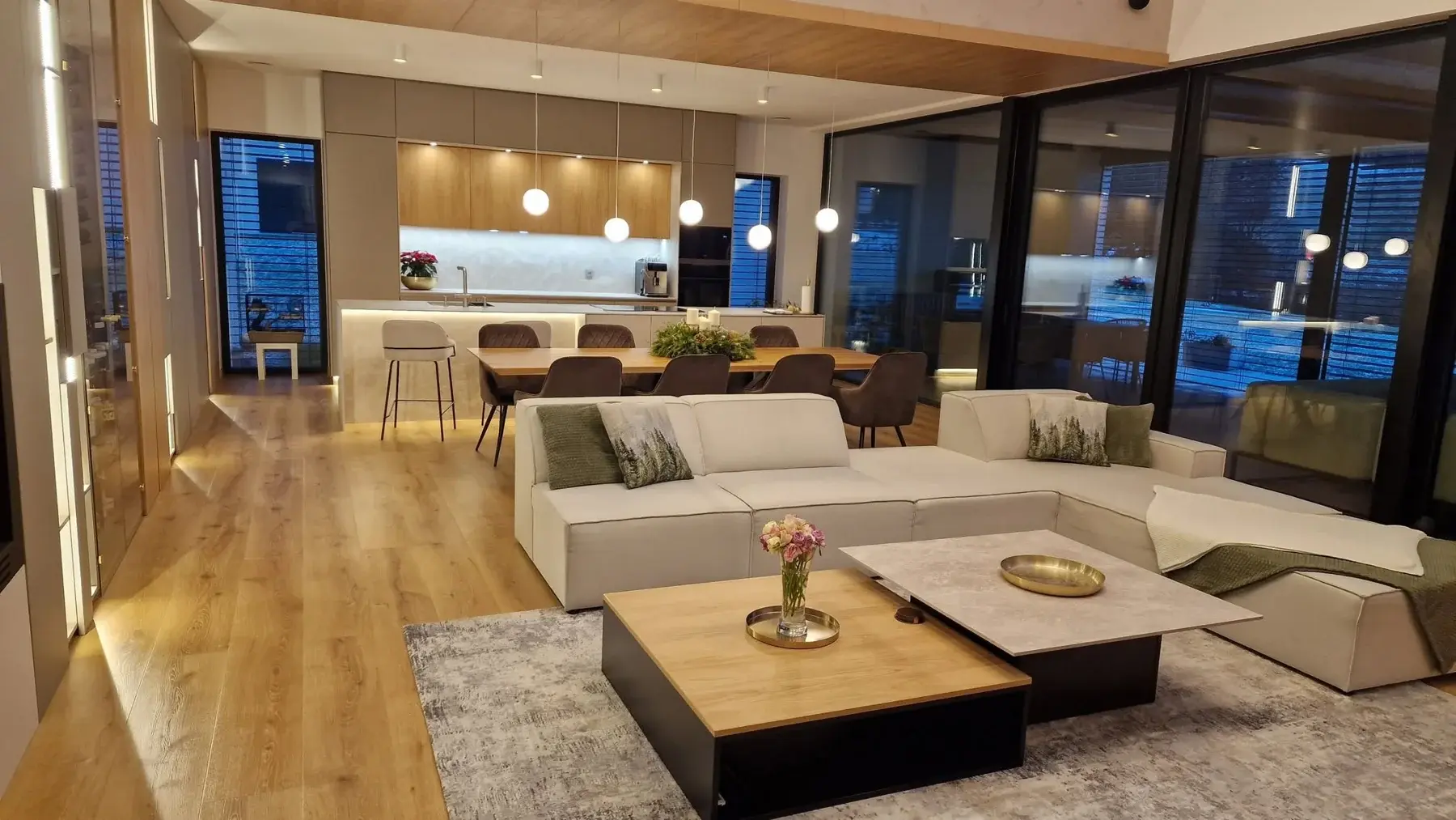 Sala de doble altura con madera y luminarias suspendidas, proyecto ejecutado de Guzman Studio